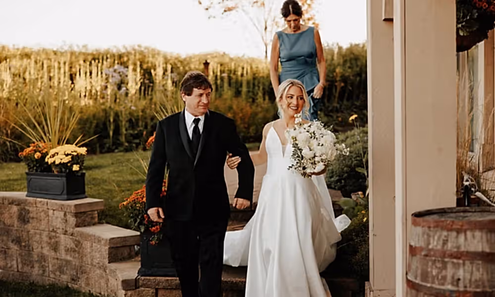 Bride holds man's arm during her ceremony at Ballyowen wedding garden. 
